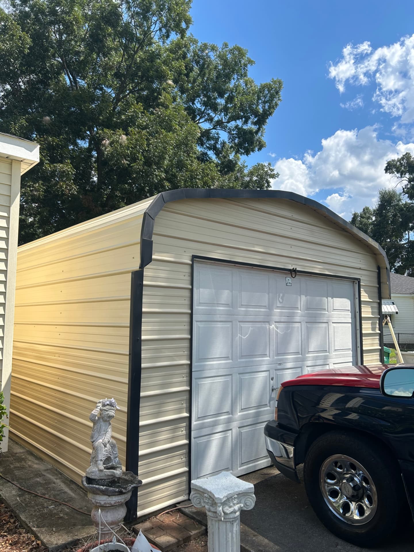 Finished metal outbuilding with freshly painted trim and a white garage door